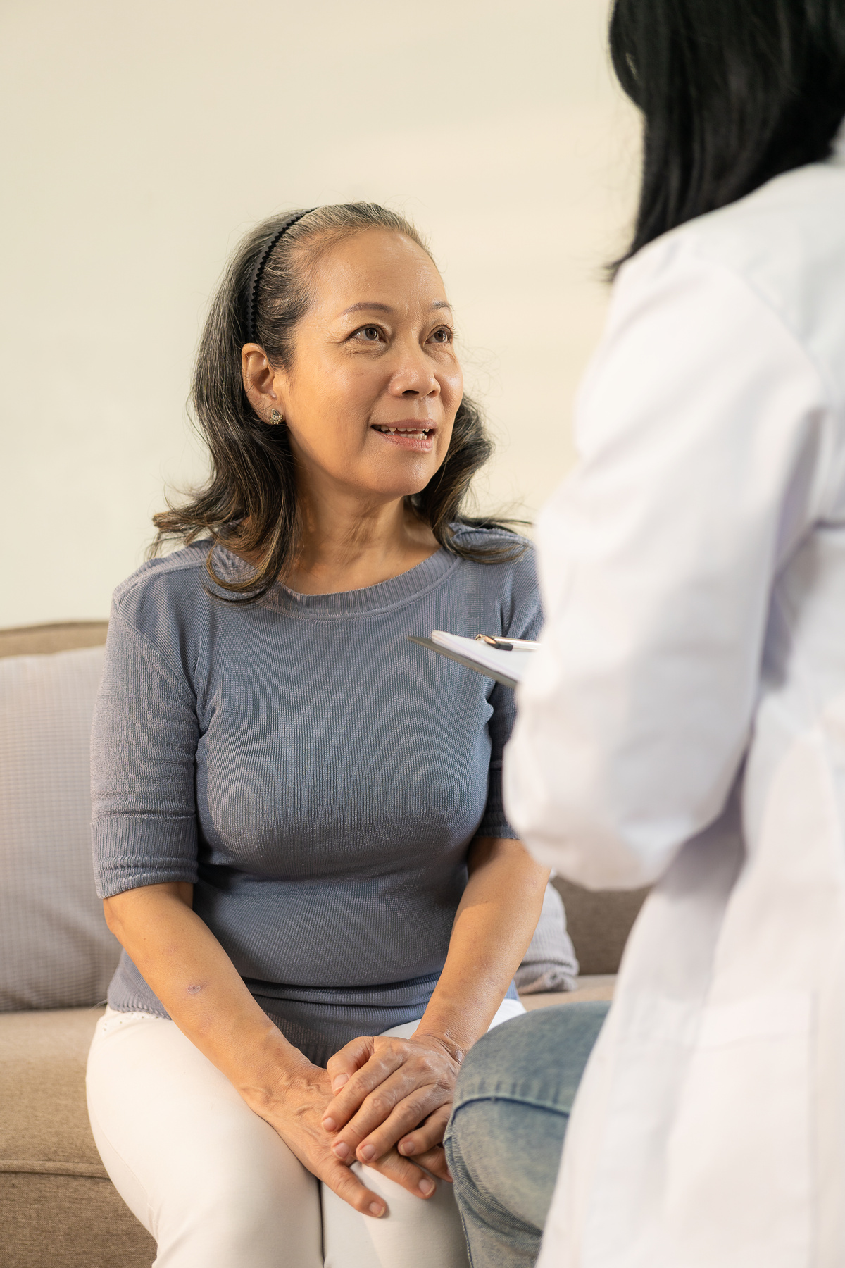 Asian female doctor talking about prescribing medicine to senior elderly patient Asian woman consulting a doctor for checkup